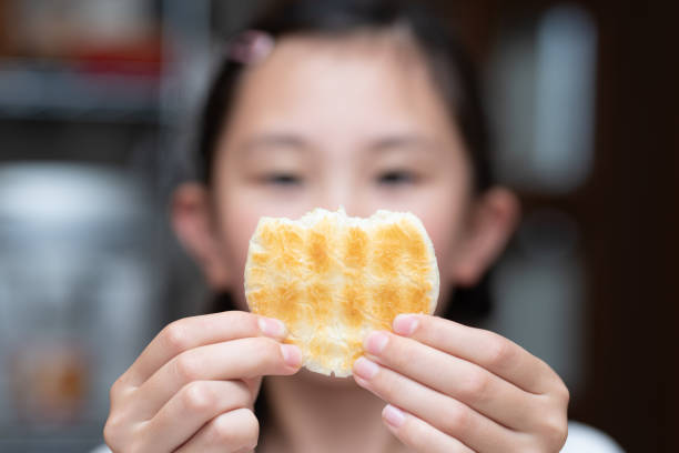 istock A child holding a half-eaten rice cracker 2158706220