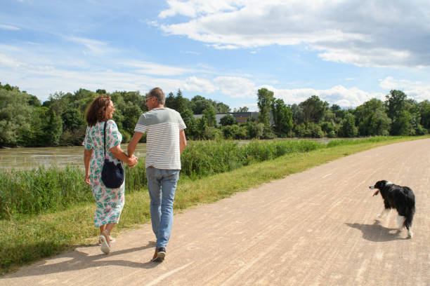 istock A senior couple walks with their dog by a river 2158714551