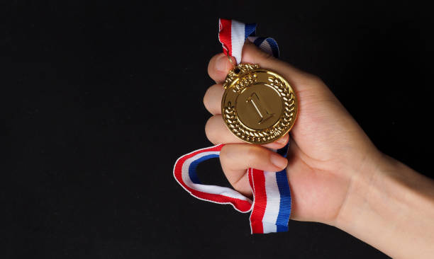 istock Hand is hold gold medal on black background 2158715709