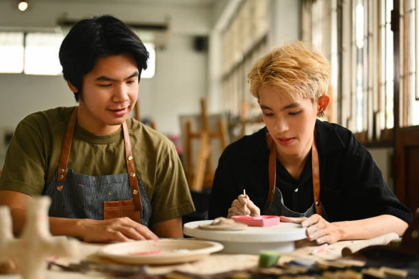 istock An art instructor observes and guides an LGBT student as they paint a ceramic piece. Both are engaged in the creative process in a well-lit studio filled with pottery tools and materials 2158718404