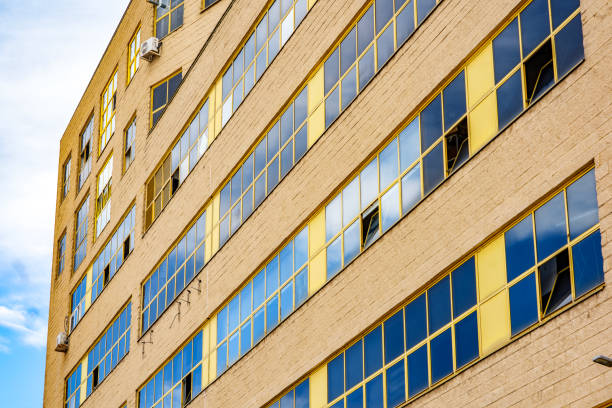 istock Industrial building featuring a large facade with yellow-framed windows, showcasing its historical architectural design. 2158718527