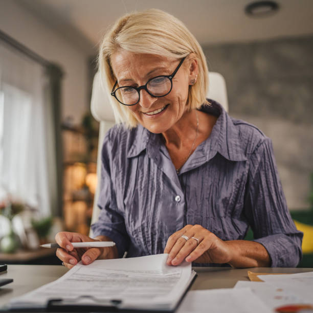 istock Mature woman work from home and sign insurance,document on clipboard 2158720778
