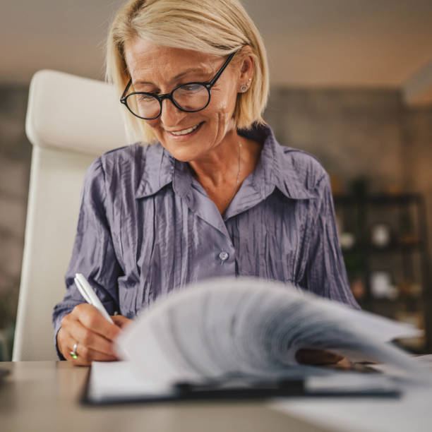 istock Mature woman work from home and sign insurance,document on clipboard 2158722108