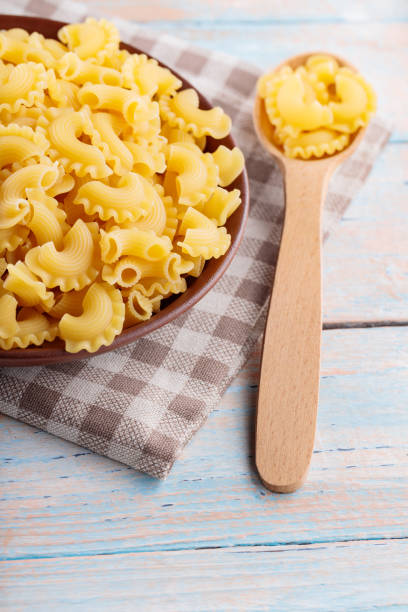 istock Raw Rooster Crests Pasta on Brown Plate, Close Up 2158724043