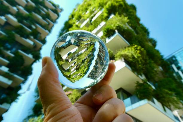 istock Hand holding crystal ball against skyscraper and trees 2158724722