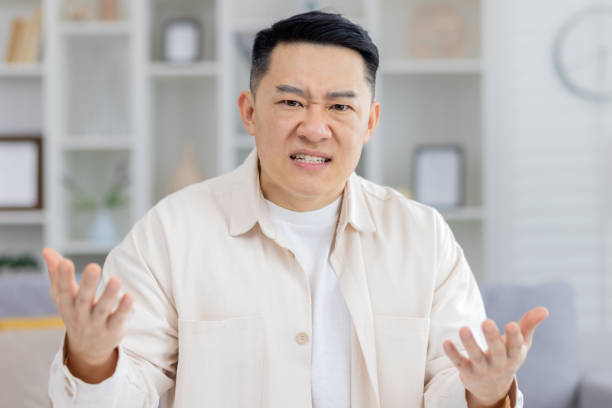 istock Frustrated man expressing dissatisfaction at home with hands raised 2158729699