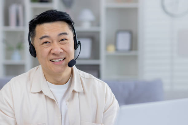 istock Smiling Asian man with headset working from home 2158731605