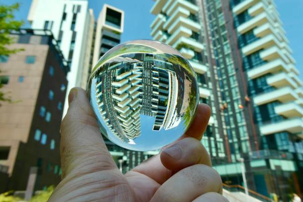 istock Hand holding crystal ball against skyscraper and trees 2158734482