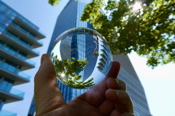 istock Hand holding crystal ball against skyscraper and trees 2158734492