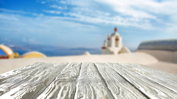 istock White wooden table top with space for merchandise products and blurred summer building view. 2158736818