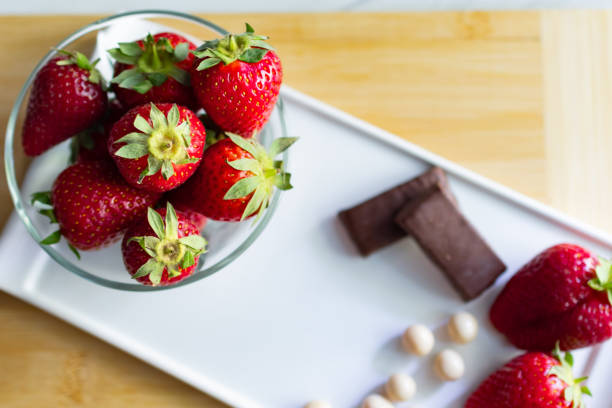 Dark chocolate covered strawberries on ceramic plate close up. Gourmet food. Dessert background.