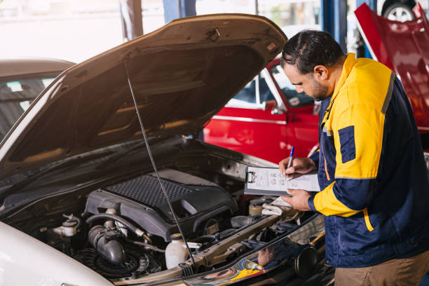 istock mechanic man checking engine open hood looking check list car maintenance service in garage workshop 2158738741