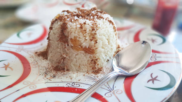 Sweet rice pudding dessert with cinnamon and raisins on decorated plate