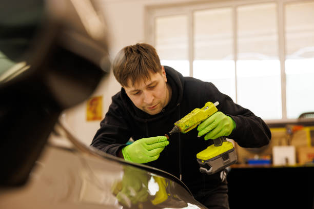 istock Wearing green gloves, a man is fixing a car equipment 2158745074