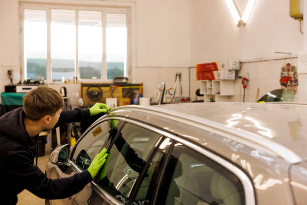 istock Man working on fixing dents on hail damaged vehicles in his own workshop 2158746141