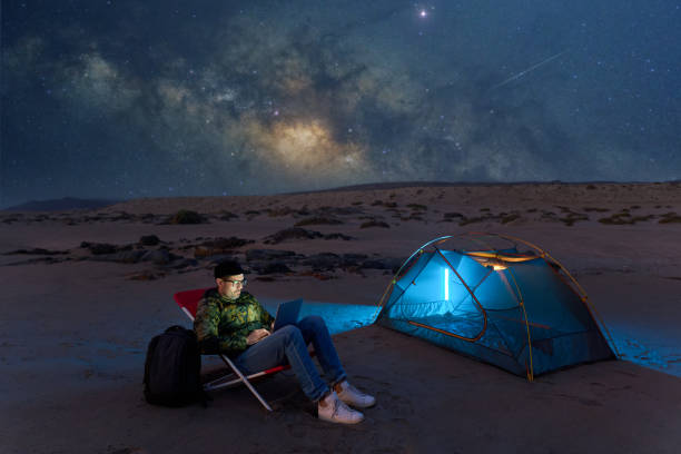 digital nomad man working with a laptop at night under the starry night