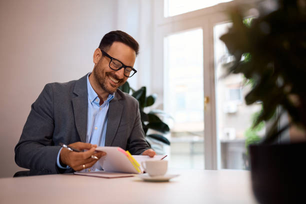 istock Happy entrepreneur going through his business notes in the office. 2158752027