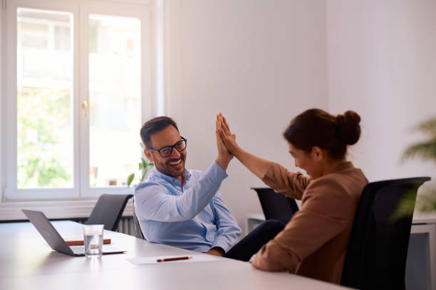 istock Happy coworkers giving high-five while working in the office. 2158752977