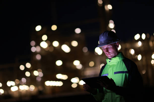 istock A smart chemical engineer using a digital tablet working late at night with a refinery plant in the background.Engineer working on outdoor building site at night. Engineers working late in power plant 2158756007