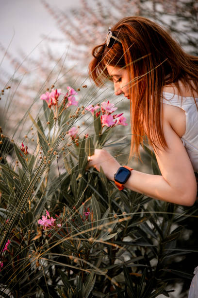 A little girl is holding a bright yellow flower, showcasing the innocence and wonder of childhood. This simple yet charming image highlights the joy and beauty found in nature, as the girl admires the delicate bloom in her hands.