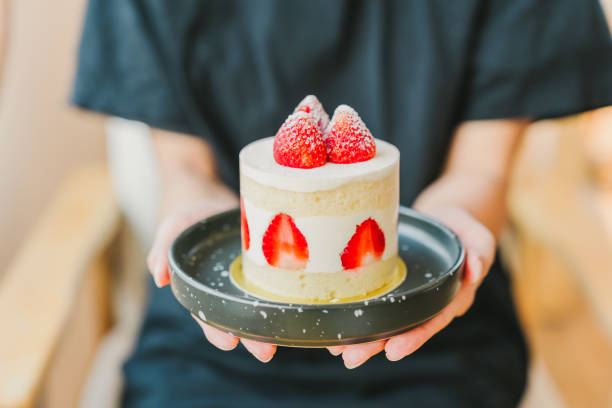istock A woman's hand is holding a strawberry shortcake. 2158768577