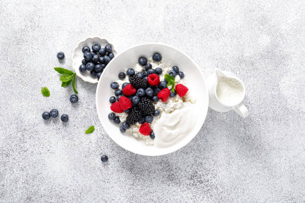 istock Cheese cottage with yogurt and fresh berries. Curd with blueberry, raspberry and blackberry, top view 2158772728