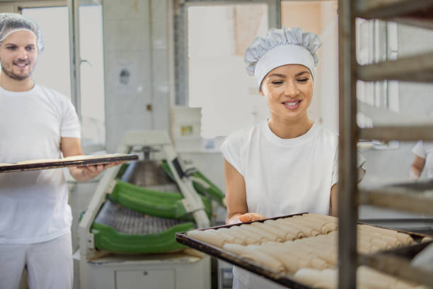 istock Chef placing tray with pastries in rack, man holding tray 2158772938