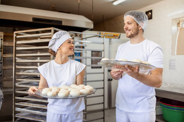 istock Chefs having conversation while holding trays of dough 2158772969