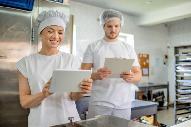 istock Smiling woman with tablet, man with clipboard in kitchen 2158772997