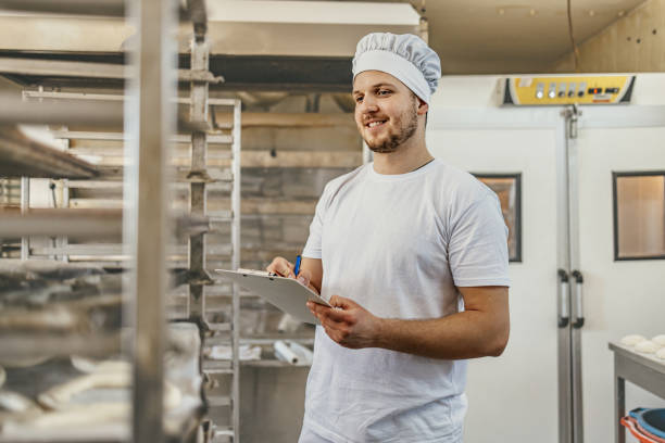istock Baker reviewing production orders in busy bakery kitchen 2158773146