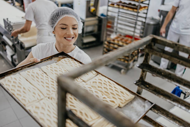 istock A baker transfers a tray of dough to a cooling rack in a busy bakery 2158774081