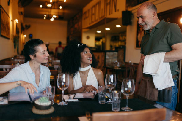 istock Two Young Women Talking To A Waiter in a Restaurant 2158774294