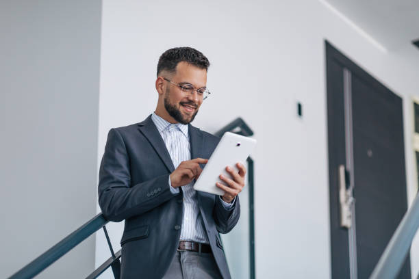 istock Businessman interacting with tablet on staircase. 2158776289