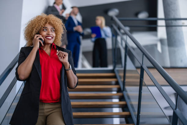 istock Curly-haired businesswoman talking on phone, smiling. 2158777219