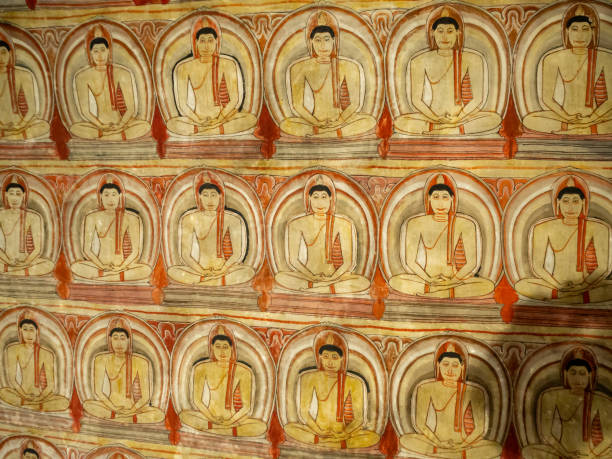 Kandy, Sri Lanka - January 5, 2018: People worshiping Buddha on fresco of the 14th century temple Lankatilaka Vihara with decorated walls on January 5, 2018. Sri Lanka has 245.000 foreign tourists per year