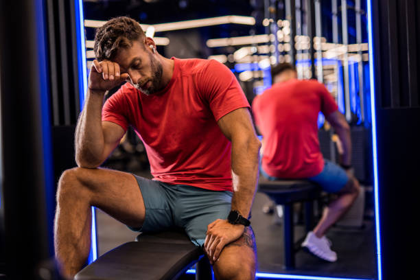 istock Exhausted athletic man resting from a workout at the gym. 2158784731
