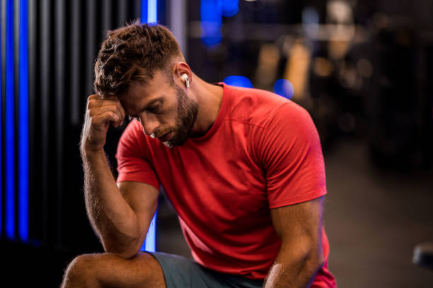 istock Exhausted athletic man resting from a workout at the gym. 2158784873