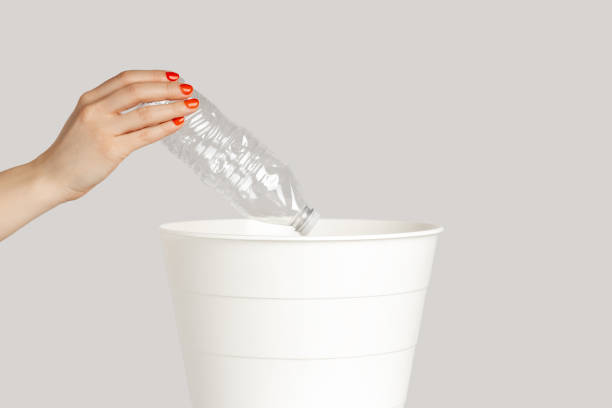 istock Woman hand throwing away empty plastic bottle, saving environment, recycle. 2158790011