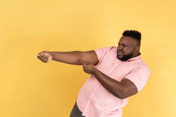 istock Man pretending to pull, , holding heavy virtual burden with expression of great effort. 2158792932