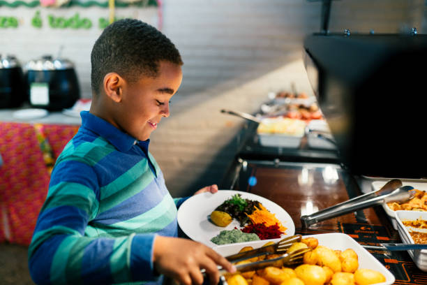 Smiling boy having lunch in a restaurant and eating healthy