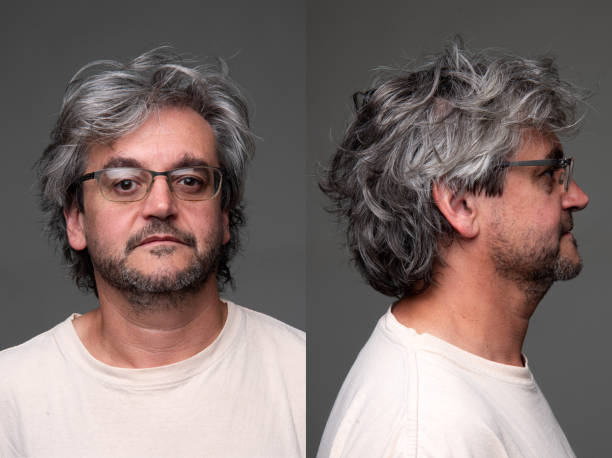 Serious mature man front and profile mugshots on gray background