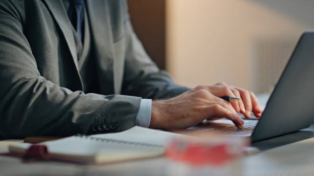 istock Closeup man hands typing laptop keyboard taking notes writing at office desk 2158794095
