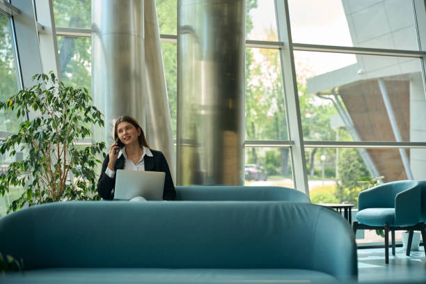 istock Young woman talking on the phone in a coworking space 2158798803