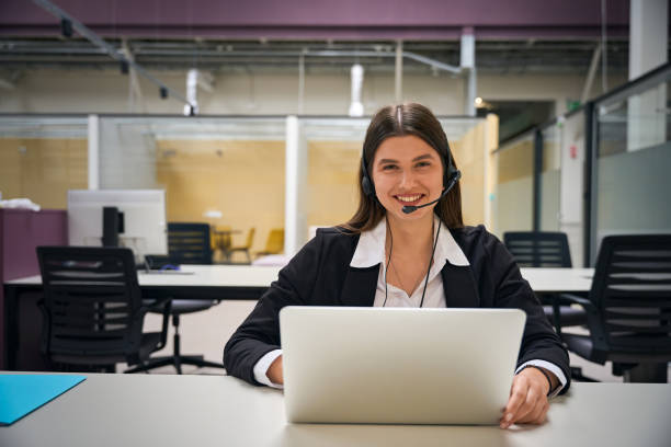 istock Lady in headphones with microphone talking to client 2158798917