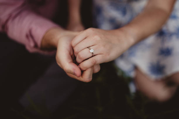 istock Engaged couple holding hands with close up of wedding ring 2158806925