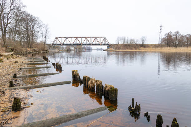 A beautiful springtime landscape with an old metal bridge over the river. NAtural springtime scenery in Riga, Latva.