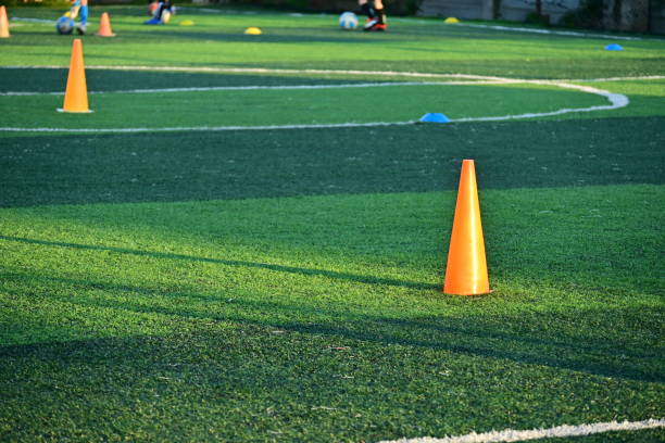 istock artificial green grass soccer field with orange training cones 2158809827