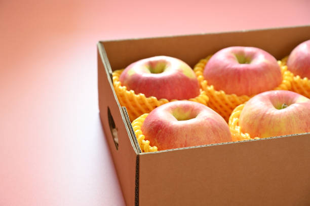 Red apples in wooden crate isolated on white background with clipping path.