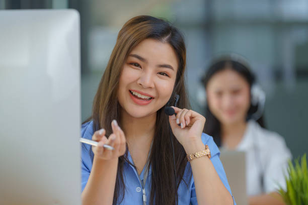 istock Happy smiling operator Asian woman customer service agent with headsets working on a computer in a call center. 2158810081
