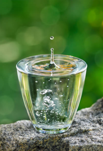 istock glass of drinking water with splash and drop on stone 2158813308